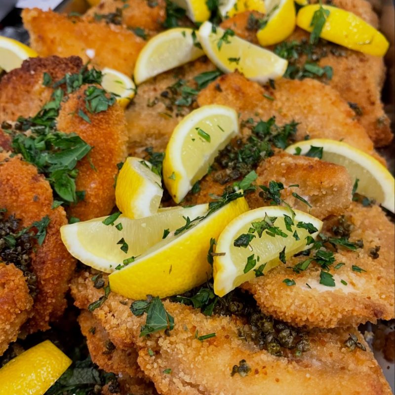 Crumbed schnitzels with lemon, capers and parsley, straight from the tray
