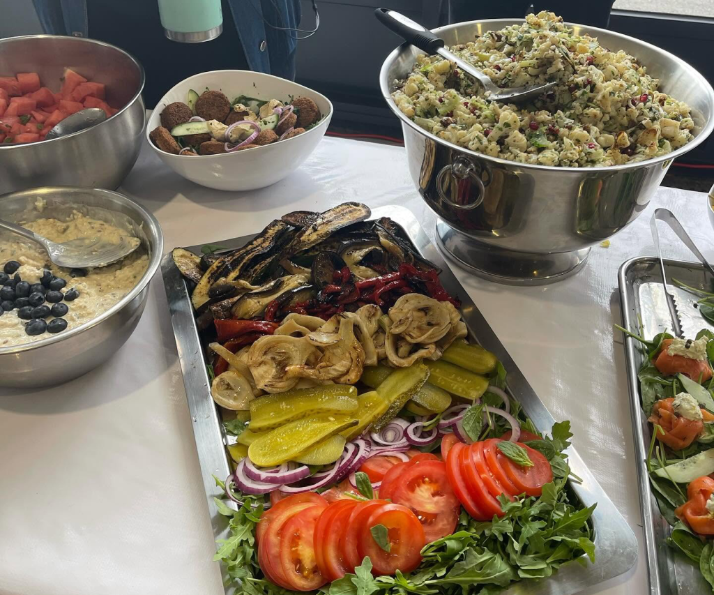 Buffet table set with platters of grilled vegetables, salads, dips and smoked salmon