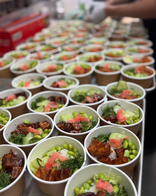 Rows of individually boxed poke bowls ready for crew service